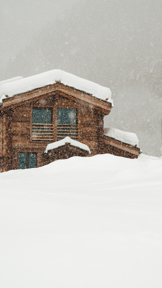 brown wooden house covered with snow